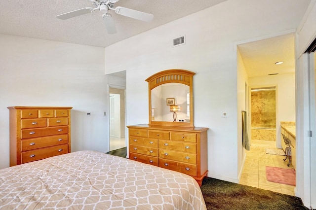 carpeted bedroom with visible vents, connected bathroom, baseboards, a textured ceiling, and a ceiling fan