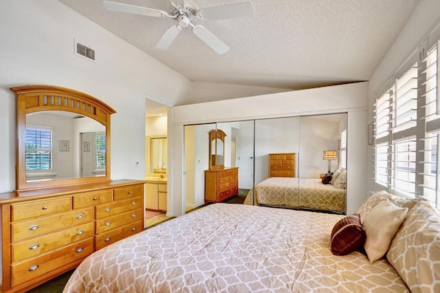 bedroom featuring visible vents, multiple windows, a closet, and vaulted ceiling