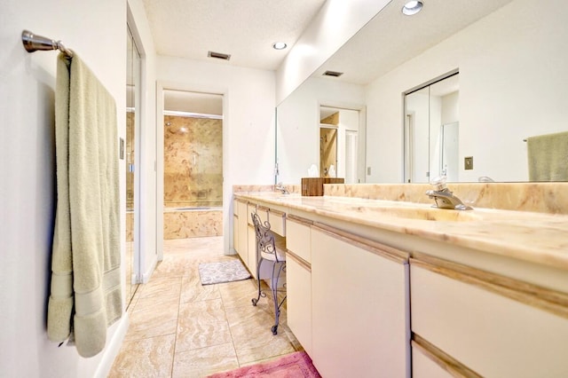 full bath featuring double vanity, visible vents, and a sink