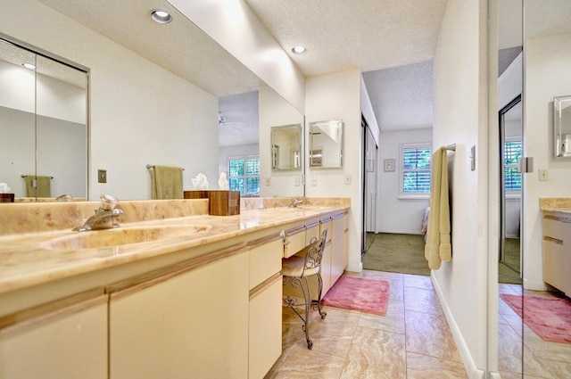 full bath featuring double vanity, a healthy amount of sunlight, and a sink