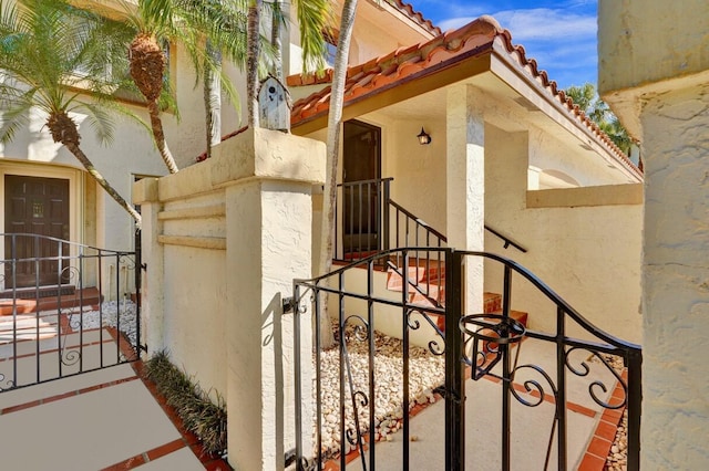 view of home's exterior featuring a gate, stucco siding, and a tile roof