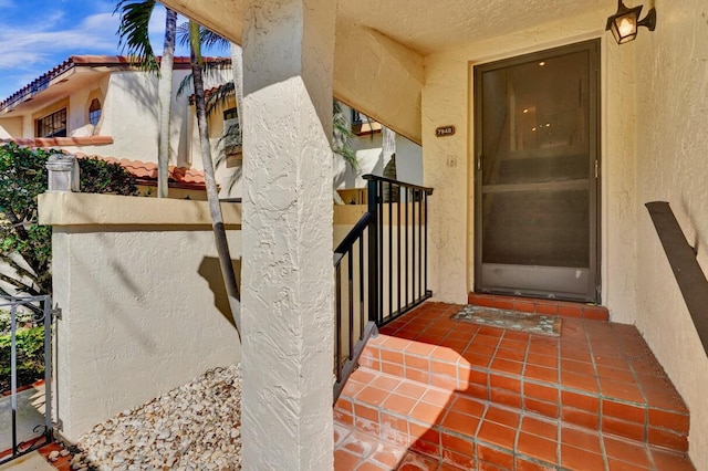 property entrance featuring stucco siding and a tile roof