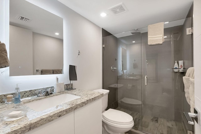 full bathroom featuring vanity, toilet, visible vents, and a stall shower