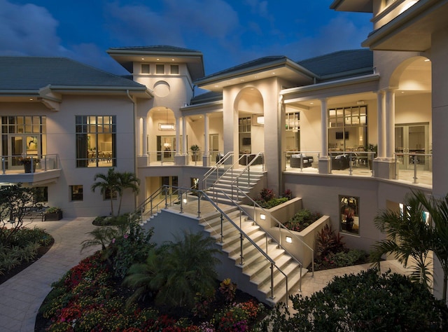 back of house featuring a patio area, stairway, and stucco siding