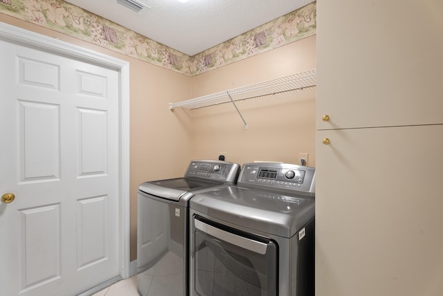 laundry room with laundry area, light tile patterned flooring, visible vents, and washer and clothes dryer