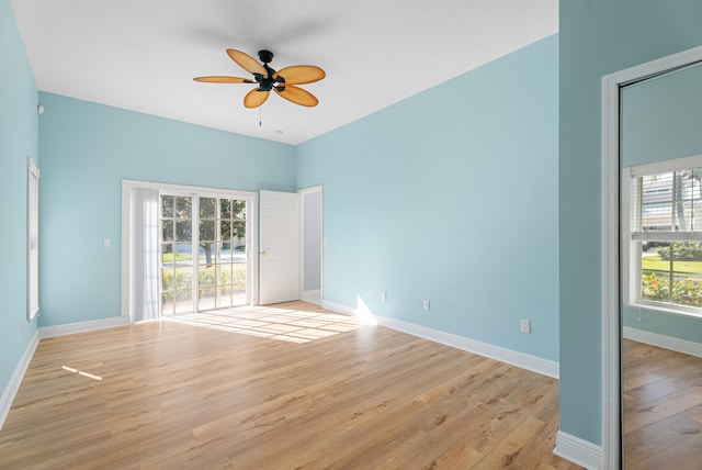 unfurnished room with baseboards, light wood-style floors, and a ceiling fan