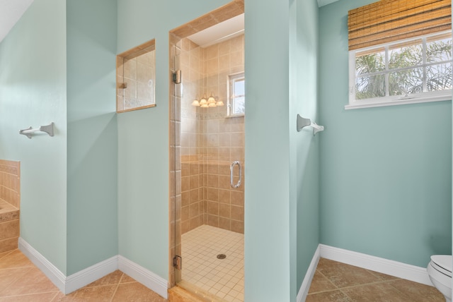 full bathroom with tile patterned floors, baseboards, toilet, and a stall shower