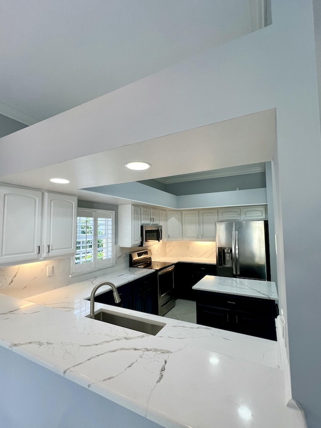 2010 NW Estuary Ct, Stuart, FL 34994 - kitchen with stainless steel appliances, dark cabinetry, backsplash, light stone countertops, and recessed lighting