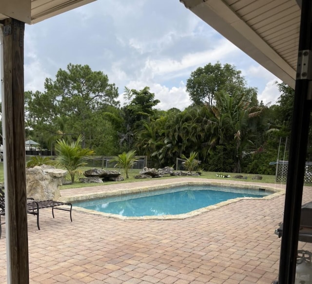 outdoor pool with a patio area and fence