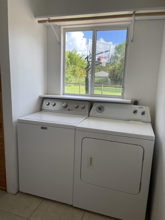 laundry room with laundry area, light tile patterned floors, and washing machine and clothes dryer