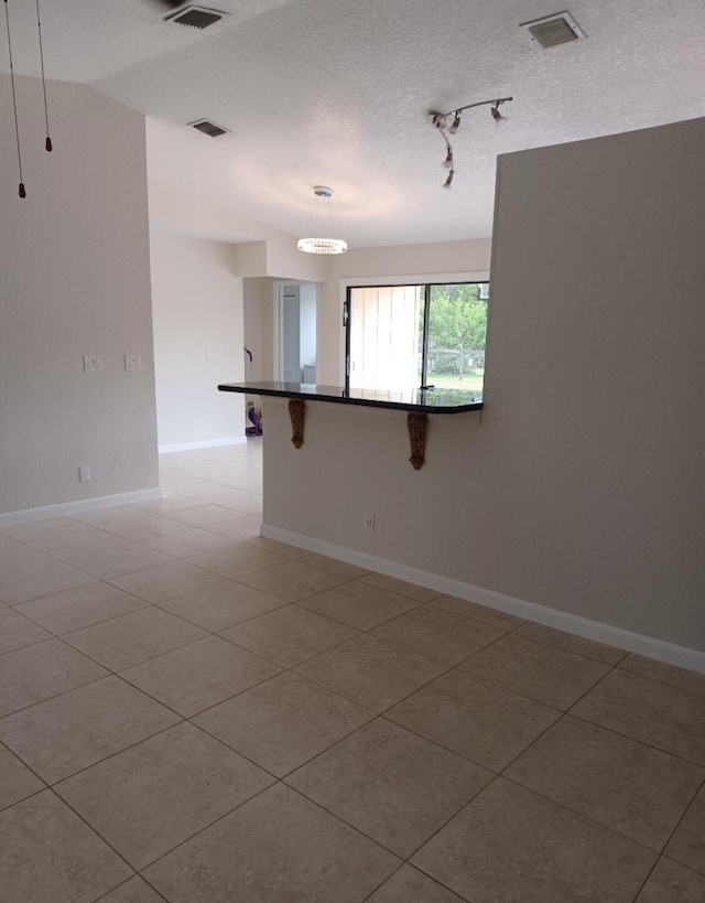 unfurnished room featuring baseboards, visible vents, and a textured ceiling