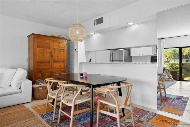 dining area with light tile patterned floors and visible vents