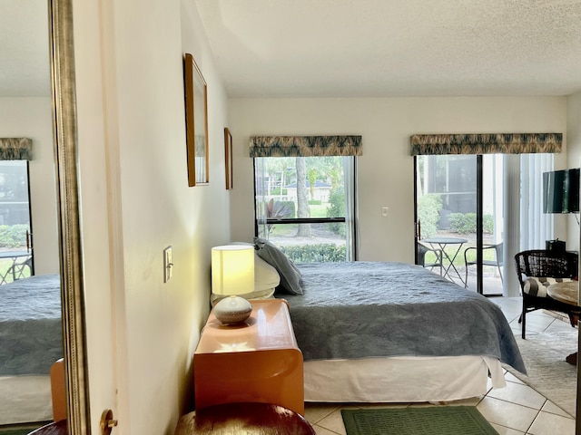 tiled bedroom with access to exterior and a textured ceiling