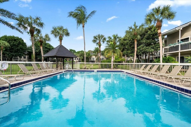 community pool with a patio area and fence