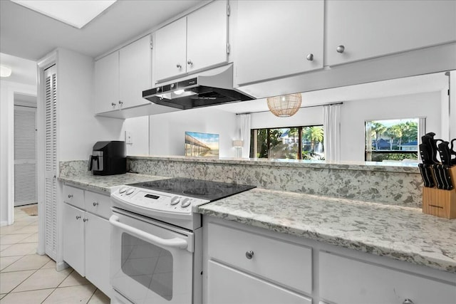 kitchen with white cabinets, light tile patterned floors, under cabinet range hood, and white range with electric stovetop