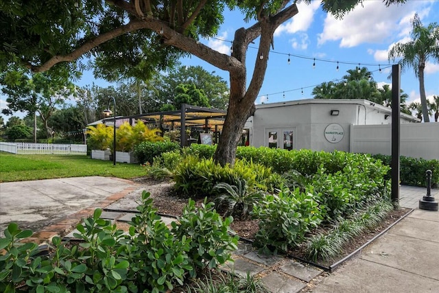 exterior space featuring stucco siding, a front lawn, and fence