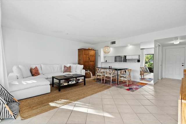 living room featuring light tile patterned flooring and visible vents