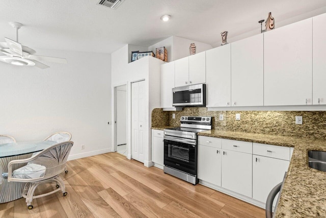 kitchen with tasteful backsplash, appliances with stainless steel finishes, light wood-style flooring, and white cabinets