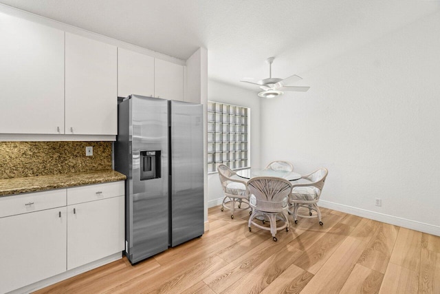 kitchen featuring stainless steel fridge with ice dispenser, ceiling fan, decorative backsplash, light wood-style floors, and white cabinetry