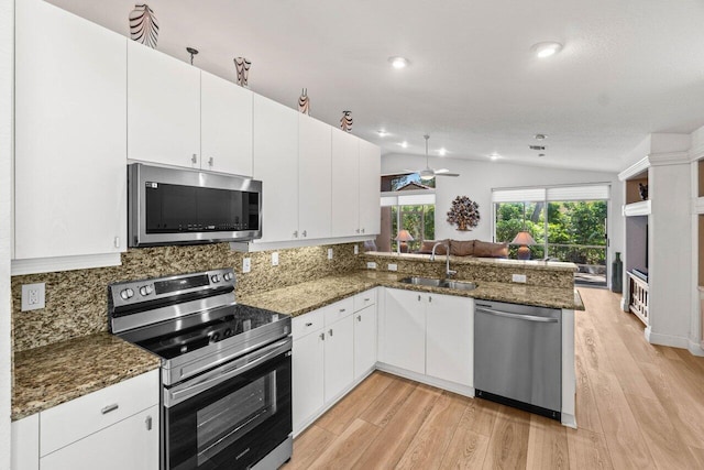 kitchen with tasteful backsplash, appliances with stainless steel finishes, a peninsula, a ceiling fan, and a sink