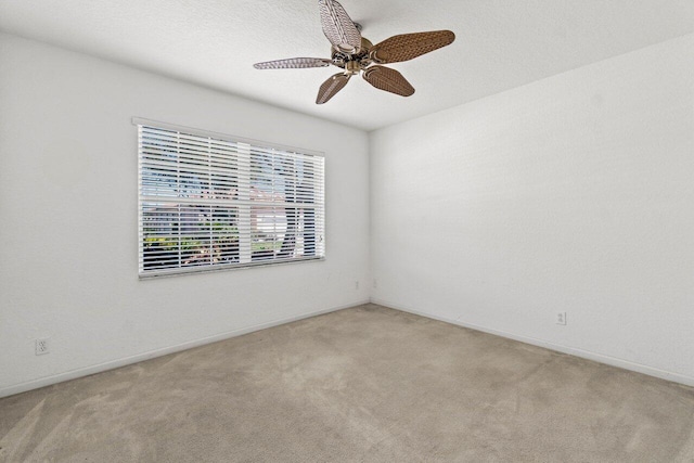 empty room featuring carpet flooring, baseboards, and ceiling fan