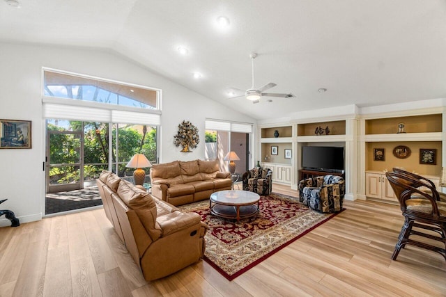 living room featuring built in features, light wood-type flooring, high vaulted ceiling, and a ceiling fan