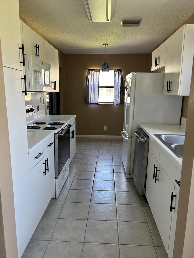 1732 W Sanderling Ln Unit 1, Fort Pierce, FL 34982 - kitchen featuring white appliances, a sink, a textured ceiling, light tile patterned floors, and white cabinetry