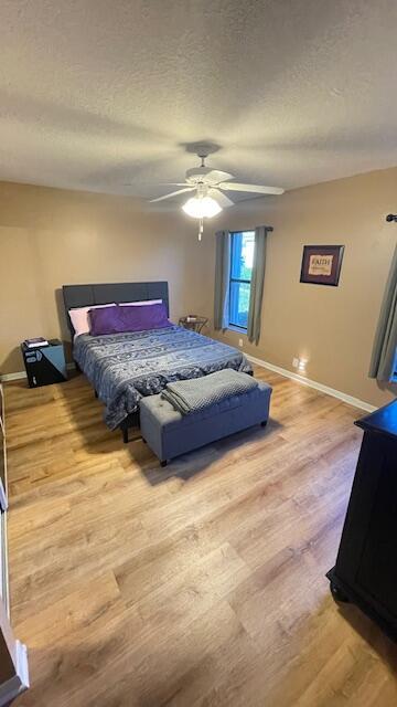 1732 W Sanderling Ln Unit 1, Fort Pierce, FL 34982 - bedroom featuring wood finished floors, a textured ceiling, baseboards, and ceiling fan