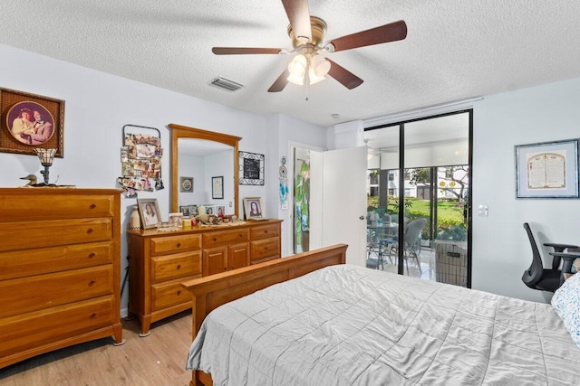 bedroom featuring access to exterior, visible vents, light wood finished floors, and a textured ceiling