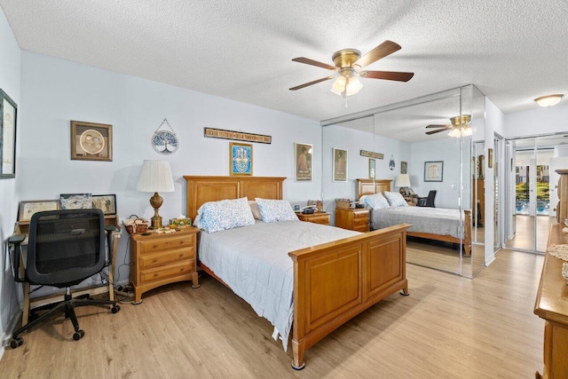 bedroom with light wood finished floors, a textured ceiling, and ceiling fan