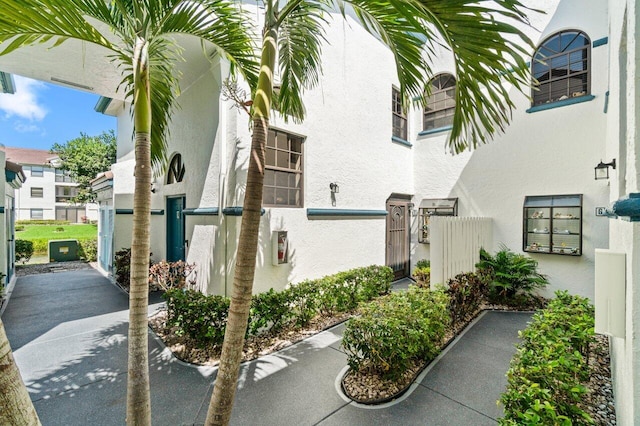 exterior space featuring a gate, fence, and stucco siding