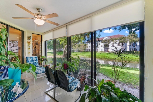 sunroom / solarium with a water view and ceiling fan