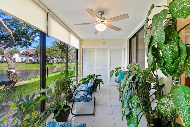 sunroom with a water view and ceiling fan