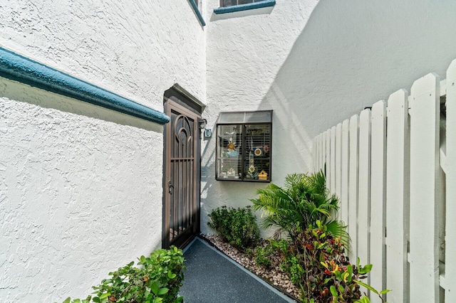 doorway to property featuring stucco siding