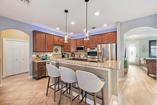 kitchen featuring light tile patterned floors, decorative backsplash, appliances with stainless steel finishes, and visible vents