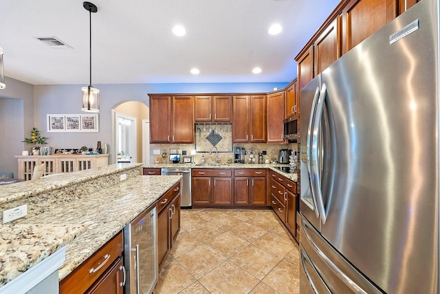 kitchen with visible vents, beverage cooler, appliances with stainless steel finishes, arched walkways, and a sink