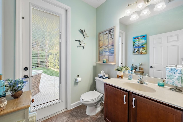 bathroom with toilet, vanity, and tile patterned flooring