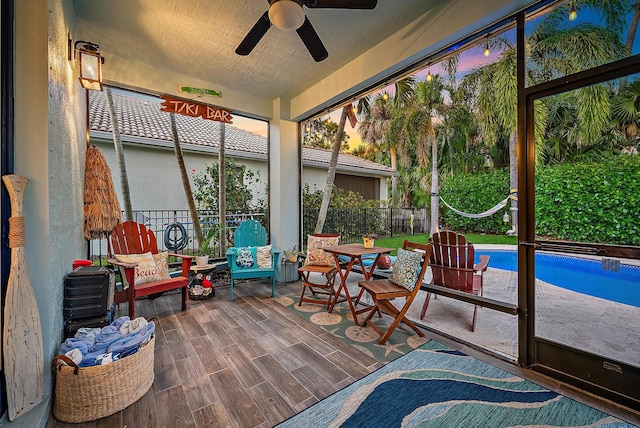 sunroom / solarium featuring a ceiling fan