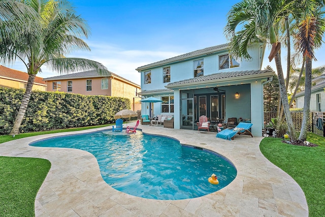 view of pool with a patio area, a fenced in pool, fence, and a sunroom