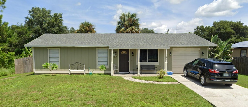 ranch-style home featuring a garage, concrete driveway, a front yard, and fence