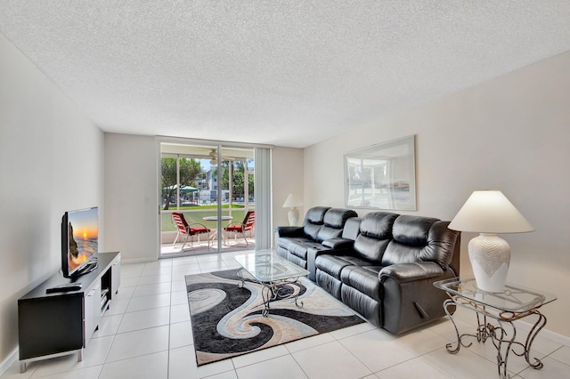 living room featuring light tile patterned floors, baseboards, and a textured ceiling