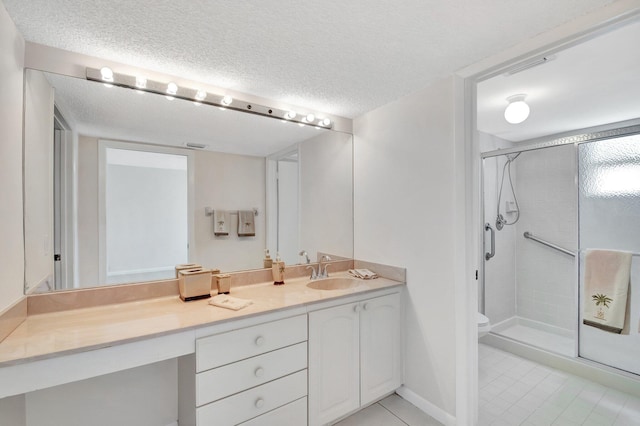 full bathroom with vanity, a shower stall, toilet, and a textured ceiling