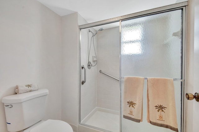 bathroom featuring a shower stall and toilet