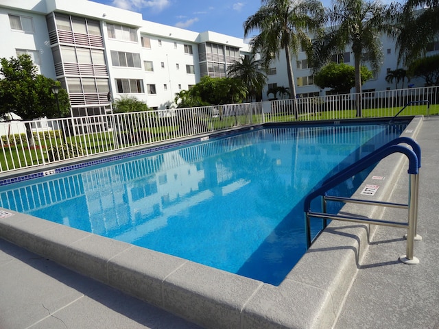 view of swimming pool with a residential view and fence