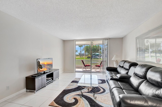 living area with light tile patterned floors, a textured ceiling, and baseboards