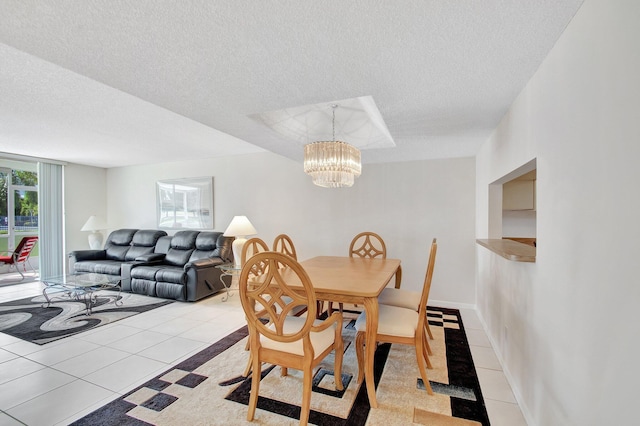 dining area with a textured ceiling, light tile patterned floors, baseboards, and a chandelier