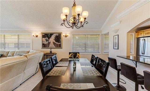 dining space with arched walkways, a notable chandelier, ornamental molding, and light tile patterned flooring