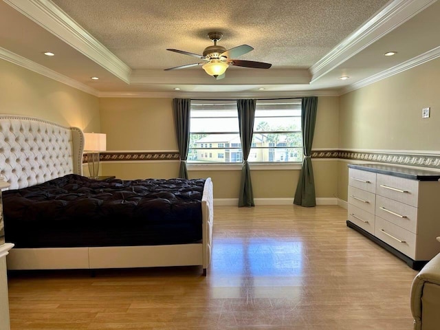 bedroom featuring a tray ceiling, baseboards, and a textured ceiling