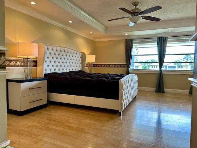 bedroom featuring recessed lighting, a tray ceiling, a textured ceiling, and ornamental molding