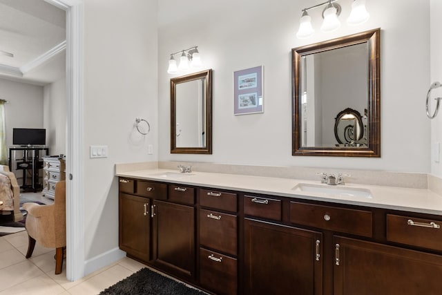 bathroom featuring crown molding, tile patterned floors, a sink, ensuite bath, and double vanity